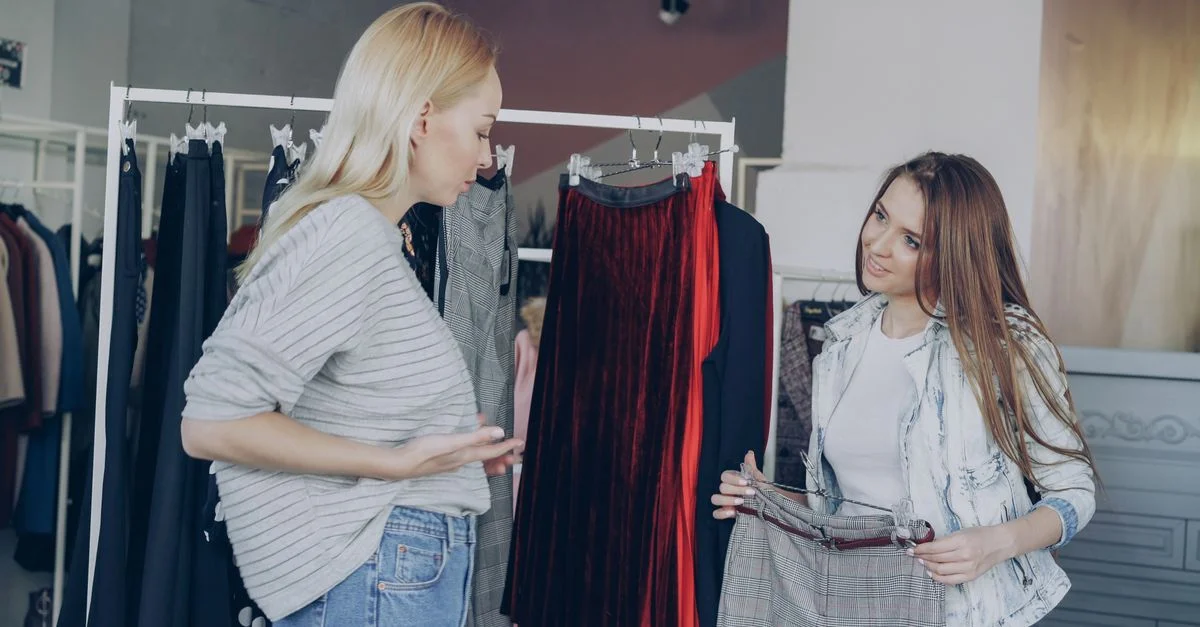 Dos mujeres mirando faldas en una elegante boutique de moda. Ambiente moderno y chic.