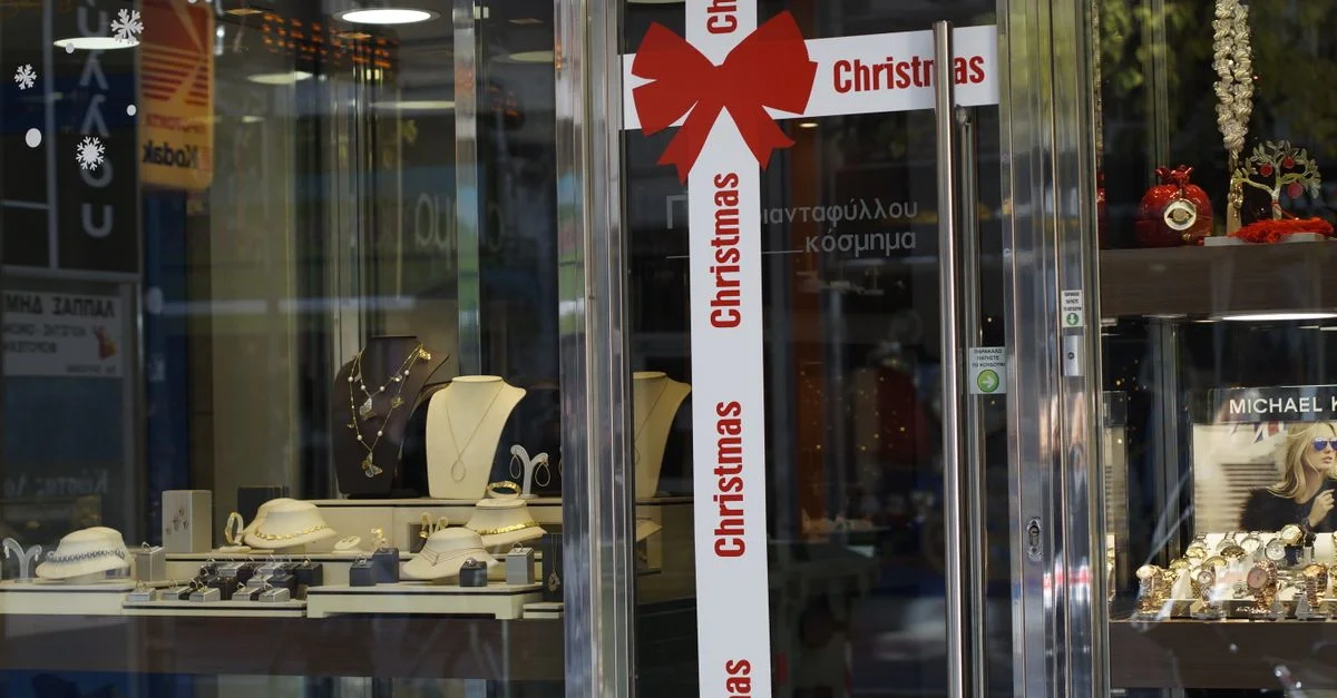 Vitrina de joyería festiva con decoraciones navideñas y una elegante selección de joyas.